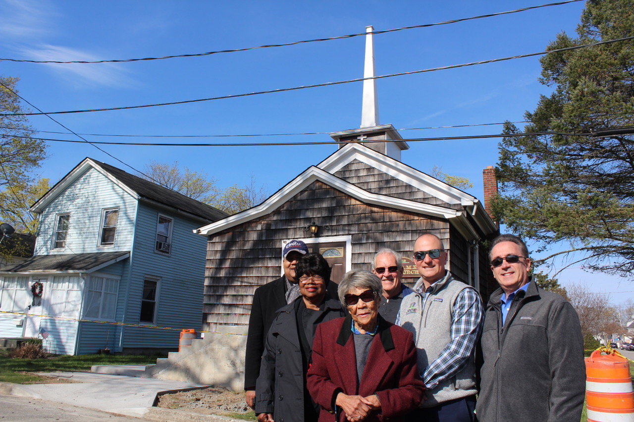 New concrete steps leading to the entrance of Grace A.M.E. Zion Church were just completed, as well as a new landing. Next comes the wooden ramp. Pictured are (left to right) Rev. William E. Fields, Rev. Jessie Fields, Patchogue Village trustee Tom Ferb, Jason Pontieri, P.E. and principal of JPCE of Medford, and Steve Walker, vice president of Rebuilding Together Long Island. In the front is Grace Church elder Ella McLean.